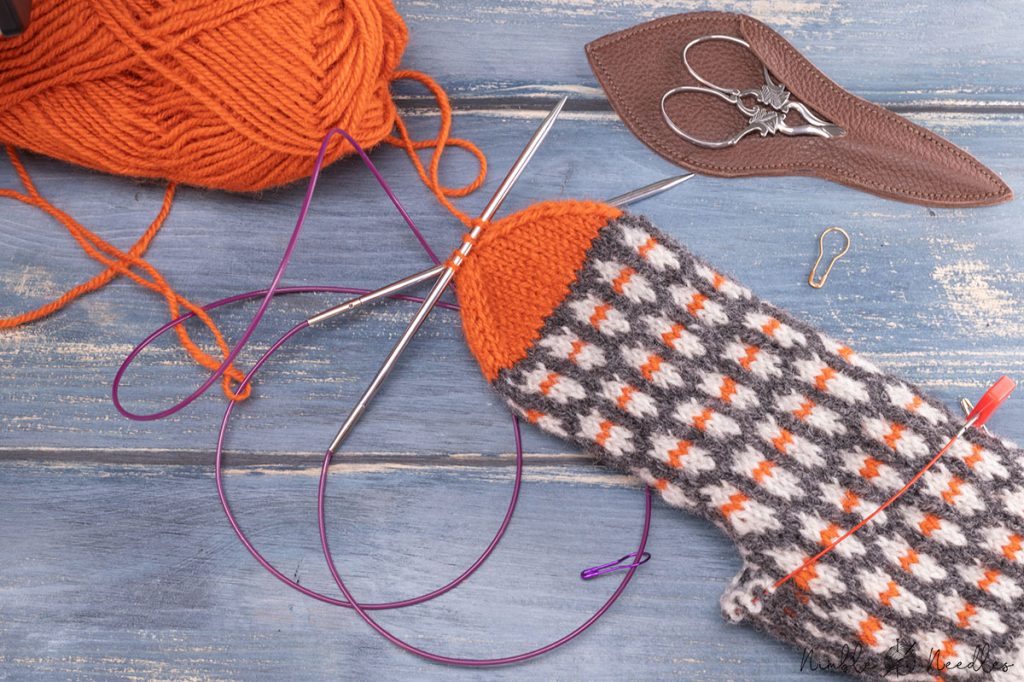someone finishing the tip of a mitten